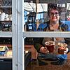 Geschützt hinter Glas: Tina Laakmann vom Bio-Restaurant &bdquo;Safran&ldquo; bei der Ausgabe von Speisen, die in Zeiten von Corona bei ...