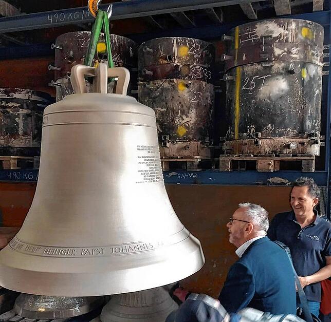 Klangprobe: Pfarrer Ulrich Sickinger schlägt mit einem Klöppel die Johannesglocke an, neben ihm Glockengießer Peter Grassmayr.