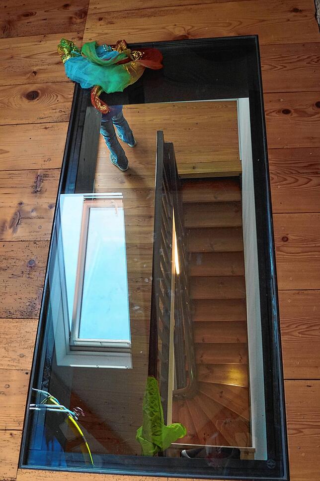 Die Luke zum ehemaligen Speicher wurde durch ein begehbares Fenster ersetzt, durch die ein Treppenraum zu erkennen ist.
