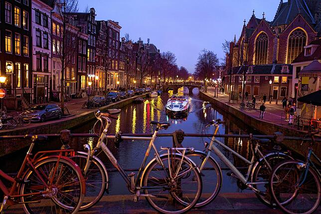 Ein Ausflugsboot fährt Touristen durch einen Kanal in Amsterdam.