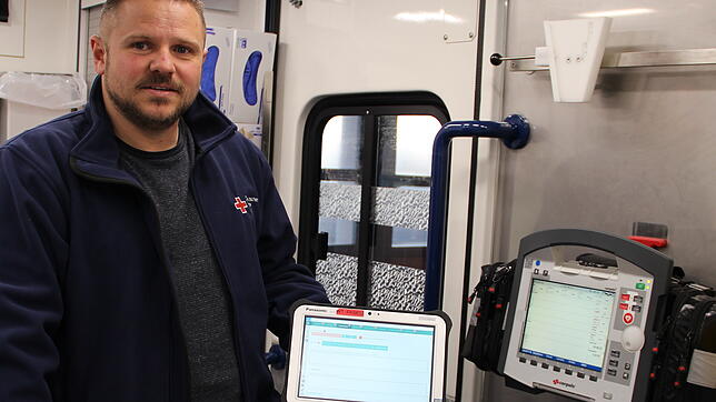 José Morla zeigt eines der speziellen Tablets, das in den Rettungswagen des Deutschen Roten Kreuzes eingesetzt wird.