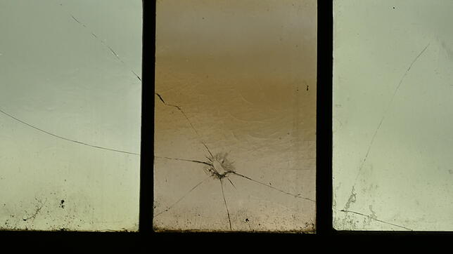 Ein wuchtigen Wurf hat ein Loch im Fensterglas verursacht.
