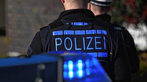 Polizisten vor einem Einsatzfahrzeug mit eingeschaltetem Blaulicht (Symbolbild). Ein Mann (57) ist in Bad Säckingen auf einen Polizisten ...