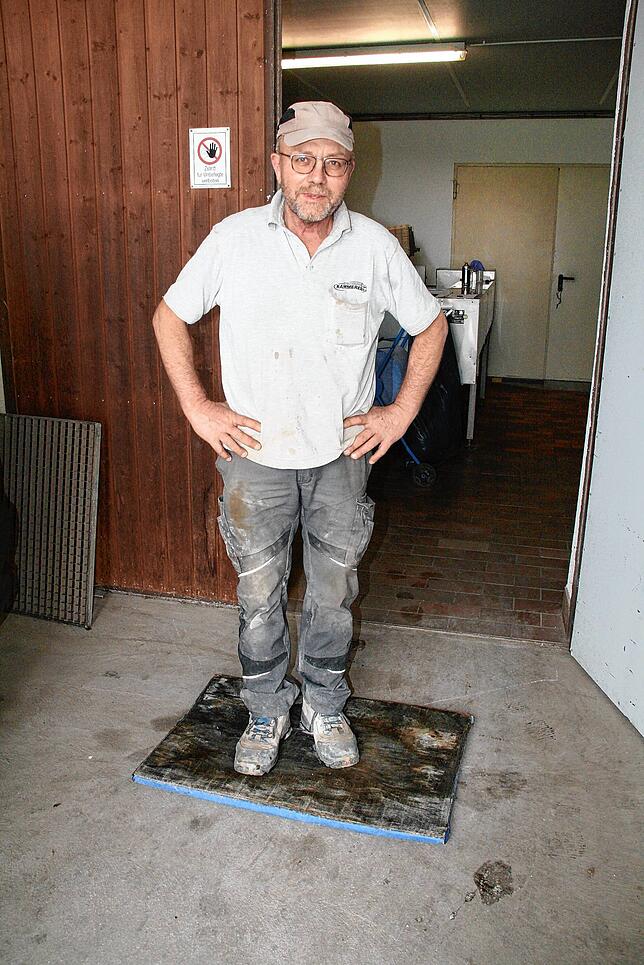 Erhard Kammerer auf einer Infektionsmatte am Eingang eines Hühnerstalls.