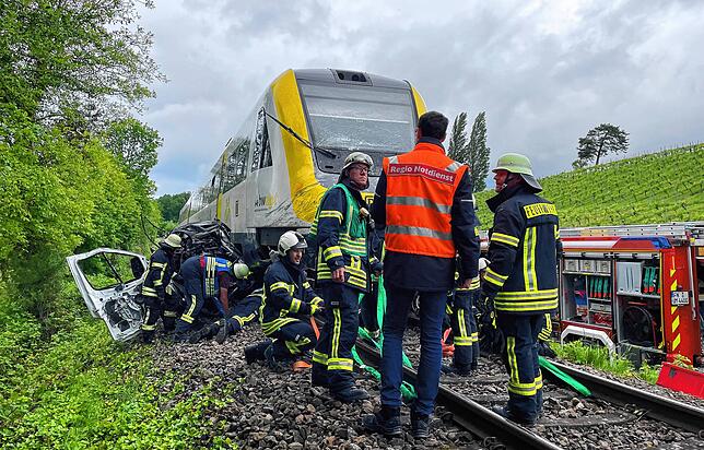Die Einsatzkräfte der Feuerwehr Uhldingen-Mühlhofen entfernen die Reste des Autowracks von den Schienen.