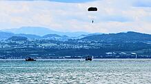 Am Freitag fanden die ersten Sprünge statt. Hier schwebt ein Fallschirmspringer über dem See. Boote nehmen die Soldaten nach der Landung ...