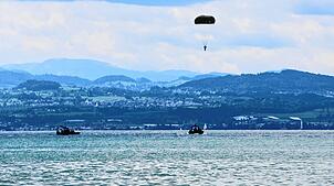 Am Freitag fanden die ersten Sprünge statt. Hier schwebt ein Fallschirmspringer über dem See. Boote nehmen die Soldaten nach der Landung ...