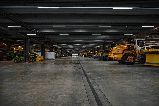 Eine riesige Halle voll mit Arbeitsfahrzeugen der Flughafen Zürich AG.