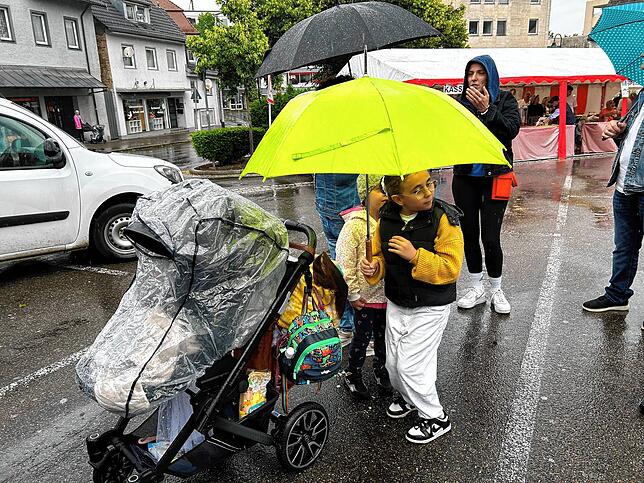 Mit Schirm und wasserdicht verpackt: Auch die Kleinsten lassen sich nicht vom Regen abhalten.