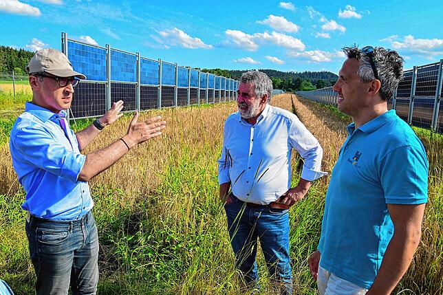 Bundeslandwirtschaftsminister Cem Özdemir (links) lässt sich die Vorteile der vertikal angeordneten Agri-PV-Anlage von Heiko Hildebrandt ...