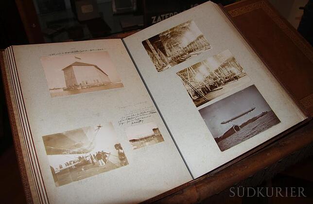 Ein übergroßes, in schweres Leder gebundenes Fotoalbum, das auf einem Podest liegt, zieht unweigerlich die Blicke jedes Besuchers der ...