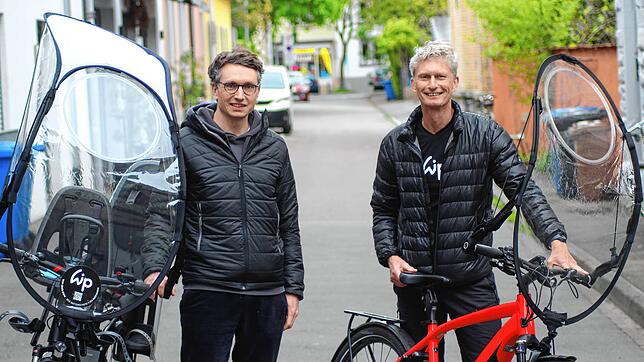 Philipp Pfeifer (links) mit dem ganzen Wip-Aufbau gegen Regen und Wind, rechts Tüftler René Wutig mit einem Fahrrad, auf dem nur die ...