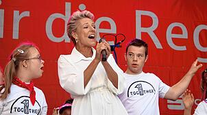 Die Sängerin Alexandra Hofmann begeistert mit dem Lied „Menschen“. Das führt sie mit einer inklusiven Tanzgruppe der Caritas auf.