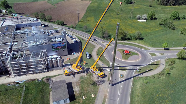Zwei große Kranen hieven den 32 Meter hohen Kamin des Schwarzwaldhofs nach oben und an seinen Standort.