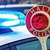 Ein Polizist hält eine Polizeikelle für eine Kontrolle auf einem Parkplatz an der Autobahn 72.