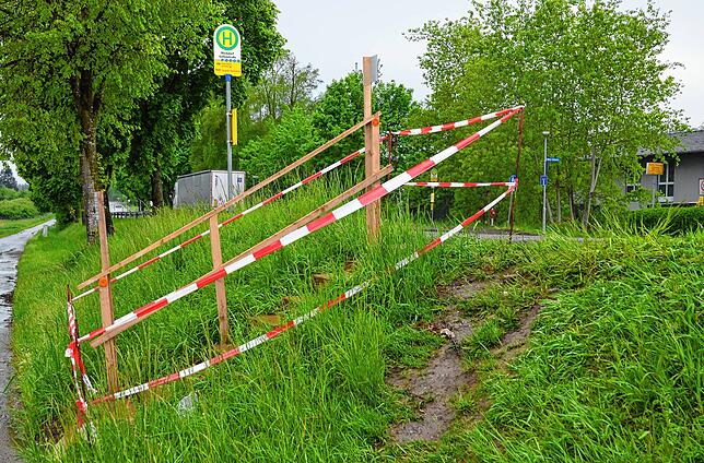 Ein kleiner niedergetrampelter Pfad führt zur Bushaltestelle, links die gesperrte Treppe Marke Eigenbau.