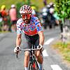 Simon Geschke im gepunkteten Trikot des besten Bergfahrers bei der Tour de France im Juli 2022. Auch der Helm passt farblich zum Hemd.