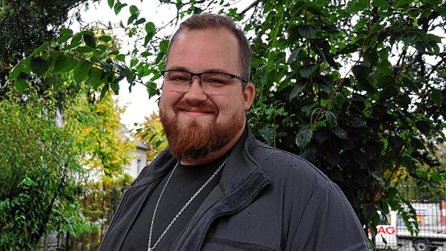 Jorin Jansen ist Pastor der Singener Friedenskirche, die 2022 abgebrannt und deren Baustelle im Hintergrund zu sehen ist. Er pflegt ein ...