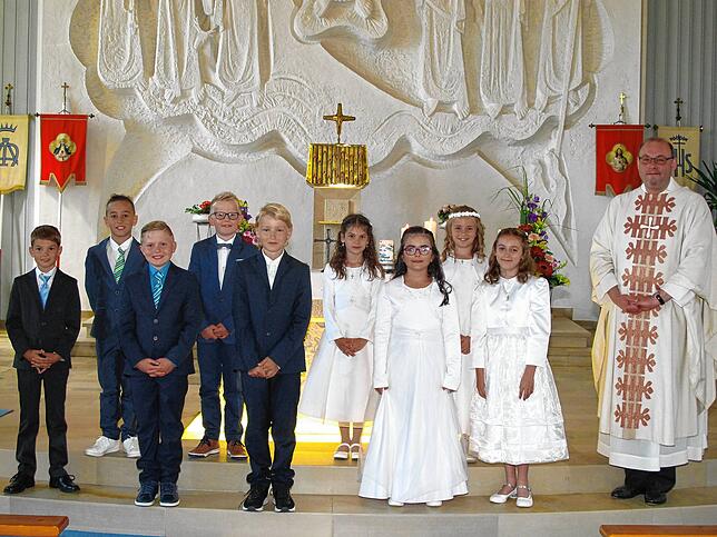 In der Schwenninger St.-Kolumban-Kirche haben fünf Jungen und vier Mädchen gemeinsam mit Pfarrer Markus Manter ihre Erstkommunion ...
