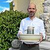 Pfarrer Florian Bosch mit Schale und Kanne für die Fußwaschung am Gründonnerstag vor der alt-katholischen Kirche in Dettighofen.