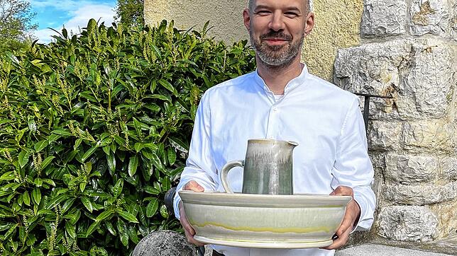 Pfarrer Florian Bosch mit Schale und Kanne für die Fußwaschung am Gründonnerstag vor der alt-katholischen Kirche in Dettighofen.