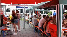 Während der Seehas im Bahnhof Mühlhausen ein- und ausfährt, feiern Dorfbewohner und Gäste vor der Abgrenzung zu den Gleisen das 28. ...