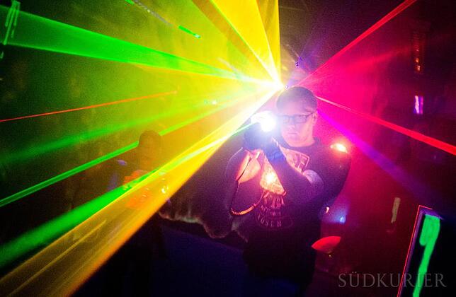 Lasergame - neue Freizeitbeschäftigung Ein Mann zielt mit einem "Phaser" auf andere Mitspieler beim Lasertag.