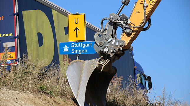 Ein Bagger bearbeitet den Erdwall, auf dem ein LKW auf der alten B31 in Richtung Singen fährt. Im Gegensatz zu PKW wird der ...