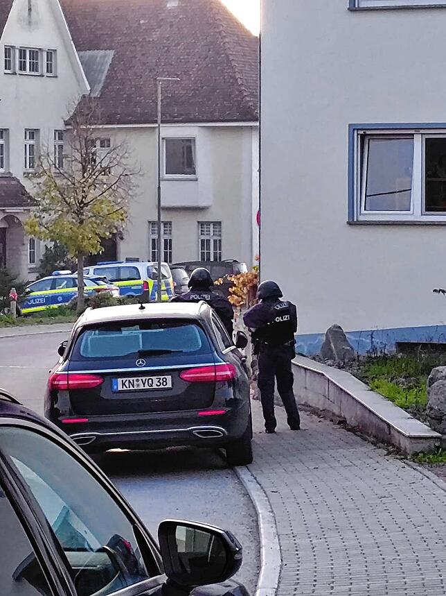 Zwei Polizeibeamte in Schutzausrüstung in der Nähe des Hauses, in dem sich der 21-Jährige befunden hat. Im Hintergrund ist die ...