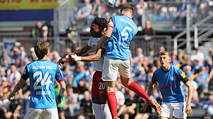 Kiels Carl Johansson (r) und Freiburgs Junior Adamu im Kopfballduell.