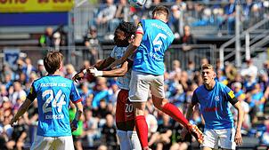 Kiels Carl Johansson (r) und Freiburgs Junior Adamu im Kopfballduell.