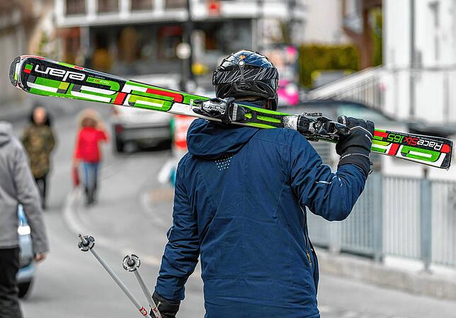 Ein Skifahrer geht mit geschulterten Skiern in Ischgl. Noch bis mindestens 26. April sind die Skiorte Ischgl, St. Anton am Arlberg und ...