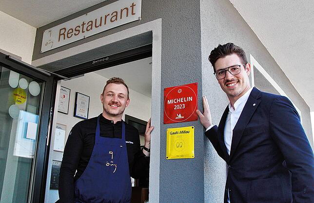 Jason und Niklas Grom freuen sich über den Michelin-Stern, der am Eingang ihres Restaurants angebracht ist.