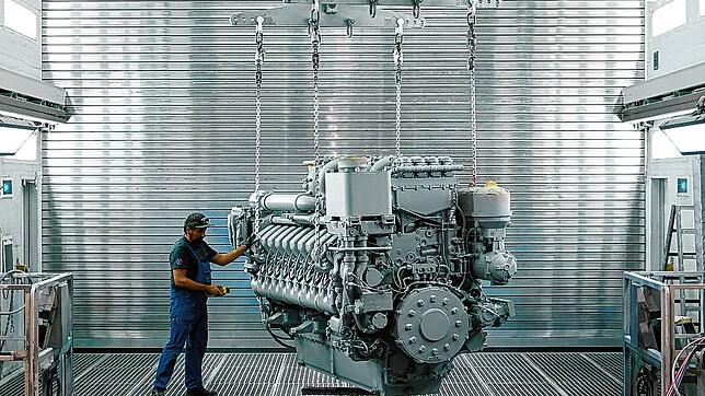 Ein schwerer Dieselmotor der 4000er Baureihe von MTU mit 16 Zylindern hängt in der Lackieranlage am Friedrichshafener Stammsitz von ...