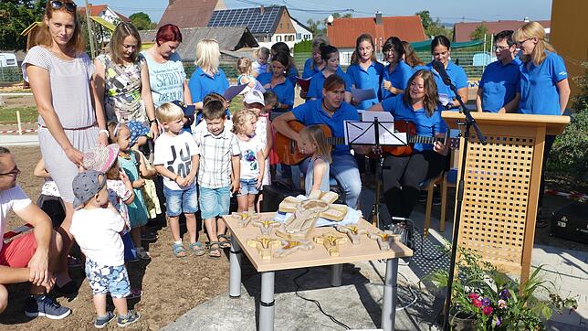 Erzieherinnen und Kindern treten bei der Einweihung der neuen Kindertagesstätte St. Georg in Behla mit fröhlichen Liedern auf. Sie ...