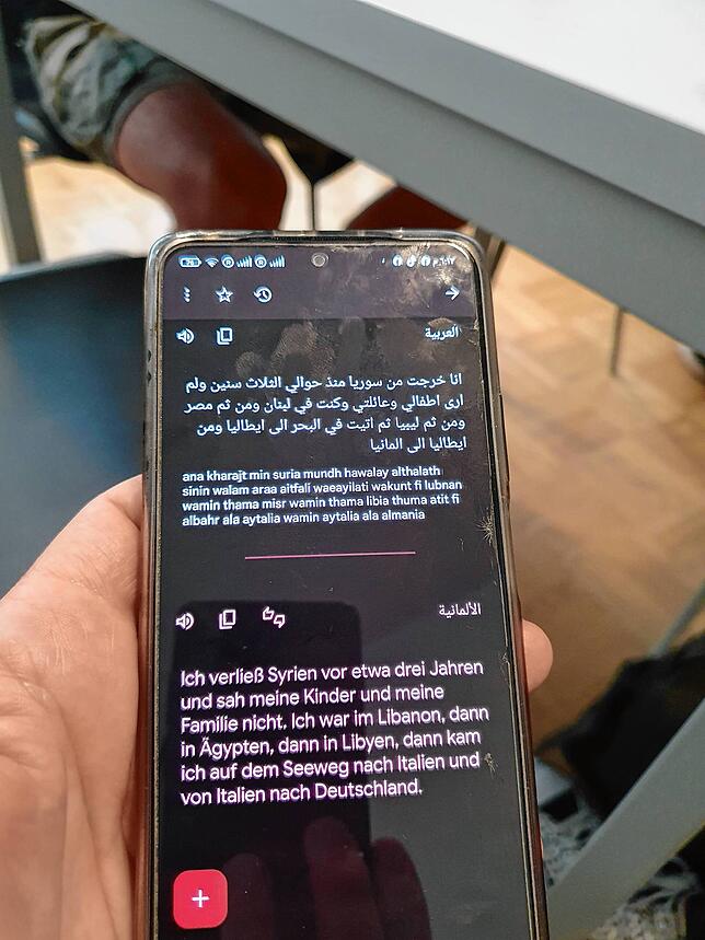 Hussein al-Tawil und sein Handy, das ihm dabei hilft, komplizierte Themen aus dem Arabischen ins Deutsche zu übersetzen.