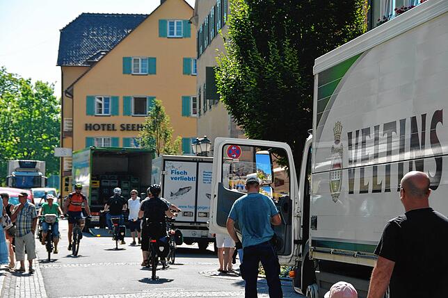 Lastwagen, Transporter, Fahrradfahrer und Fußgänger müssen aneinander vorbei.