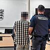 Der Angeklagte wird zur Verhandlung in den Sitzungssaal geführt. Im Hintergrund sein Verteidiger Uwe Rung.