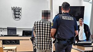Der Angeklagte wird zur Verhandlung in den Sitzungssaal geführt. Im Hintergrund sein Verteidiger Uwe Rung.