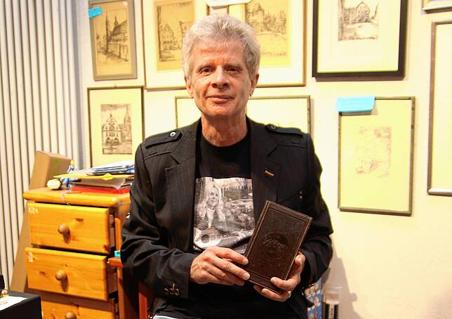 Andre Baumgartner hinter der Verkaufstheke der Bücherinsel in der Niederen Straße. Ende April 2026 wird er dort ausziehen. In der Hand ...