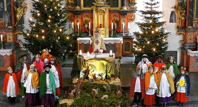 Die Sternsinger in Jestetten hatten sich um die Krippe versammelt, bevor sie von Pfarrer Richard Dressel ausgesandt wurden.