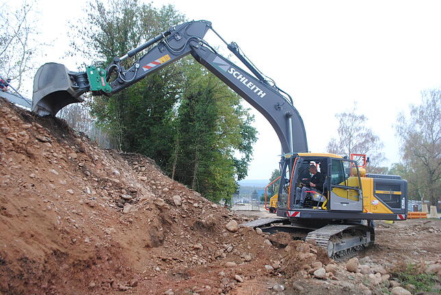 Blick auf den Hang: Der Bagger gräbt die Erde für einen neuen Abwasserkanal um.