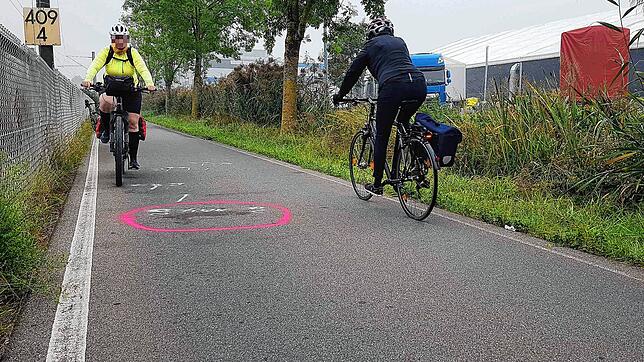 Hier kam der Rennradfahrer, der so wie die Radlerin in Gelb auf dem Bild stadtauswärts unterwegs war, zu weit nach links ab. Er streifte ...