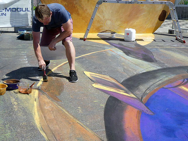 Sorgfältig trägt 3D-Maler Nikolaj Arndt die Farbe auf den Asphalt des Blumberger Marktplatzes auf. Jeder Strich muss sitzen.