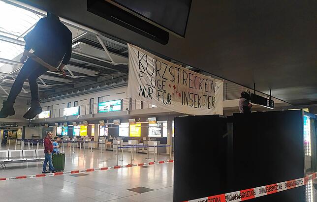 „Kurzstreckenflüge nur für Insekten“ steht auf diesem Banner.