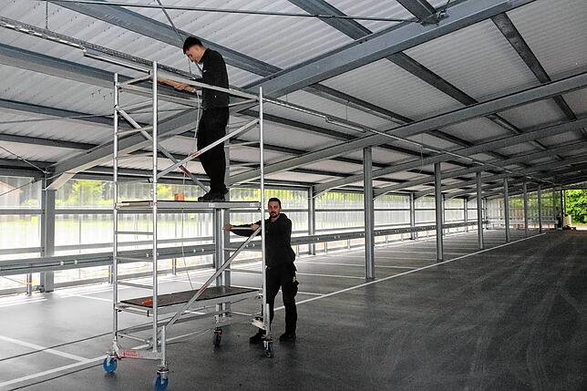 Im neuen Parkdeck arbeiten an diesem Tag die beiden Elektriker Paul Mundinger und Mathy Strobel (von links) von der Firma Mundinger ...