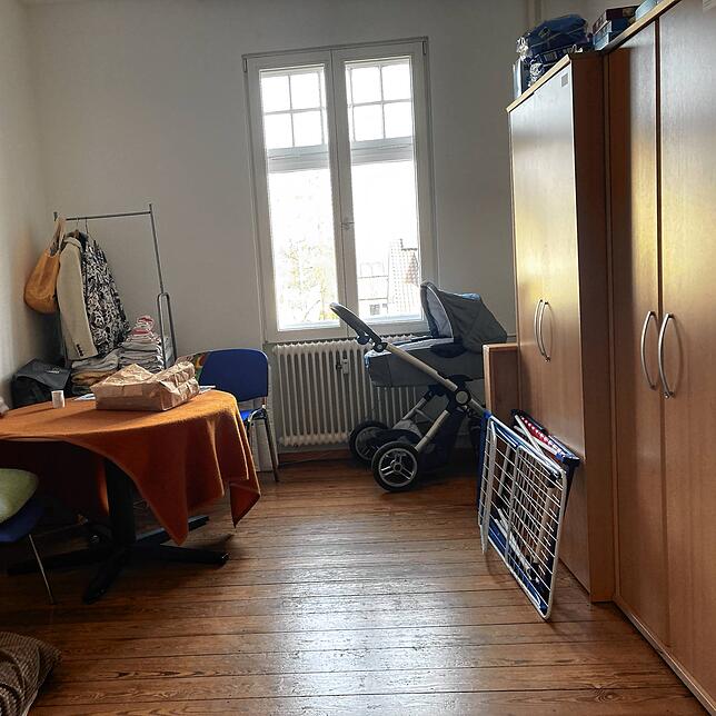 Das Kinderzimmer ist mithilfe der Nachbarn mit Möbeln, Spielzeug und Kinderwagen ausgerüstet.