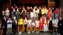 Das gesamte Ensemble der Theater-AG der Realschule Jestetten präsentiert sich auf der Bühne. Hinten in der Mitte steht die Protagonistin ...