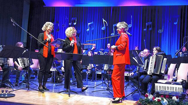 Zwei Spielerinnen bedanken sich im Namen des Orchesters bei der Dirigentin Martina Vitacca für ihre verdienstvolle Arbeit.