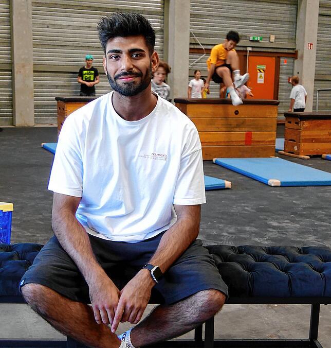 Danial Khan, einer der Gründer von Team Fox, ist stolz auf die Kinder, die im Hintergrund Kästen mit verschiedenen Techniken überspringen.